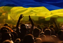 Українське суспільство після трьох років війни: трансформація, що змінила країну Люди з українськими прапорами