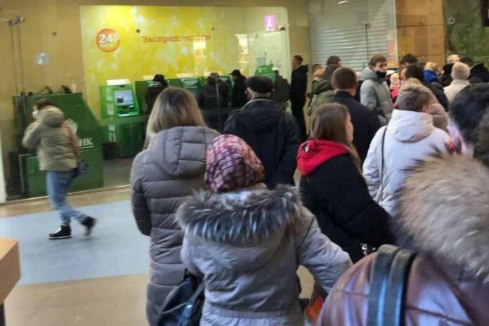 01d81b22a177e21535e74a92e4ab8e4f Росіяни у черзі до банкомата після нових фінансових обмежень.