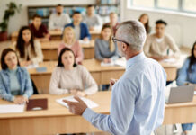 Вчителька пише на дошці у класі