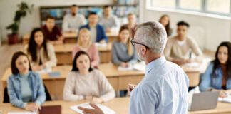 The teacher writes on the blackboard in the classroom