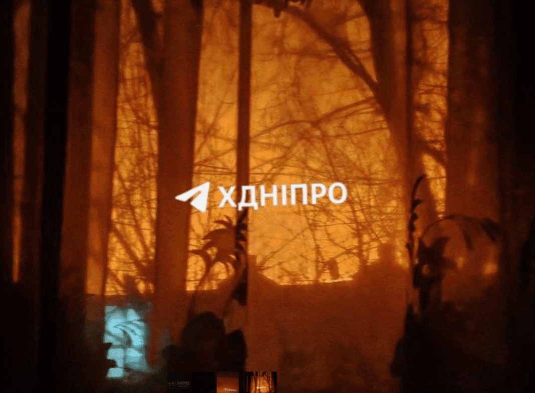 Нічний Дніпро під час атаки БПЛА, в небі видно спалахи роботи ППО.