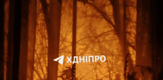 Нічний Дніпро під час атаки БПЛА, в небі видно спалахи роботи ППО.