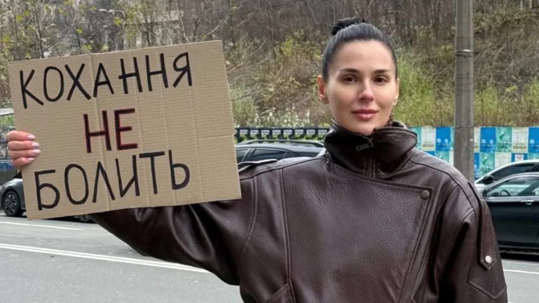 image Masha Efrosynina with a poster «If she hits, she hits» during a campaign against domestic violence