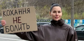 Masha Efrosynina with a poster «If she hits, she hits» during a campaign against domestic violence