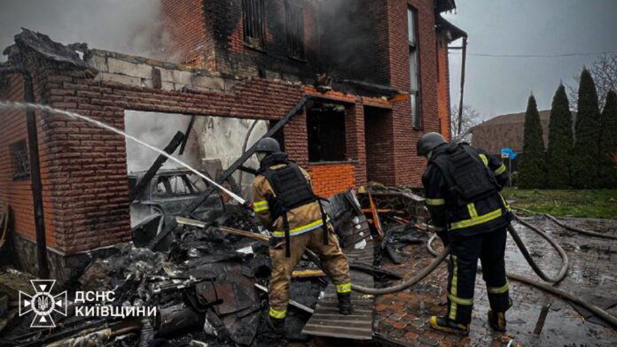 Rescuers extinguish fire in a destroyed house in Kyiv region