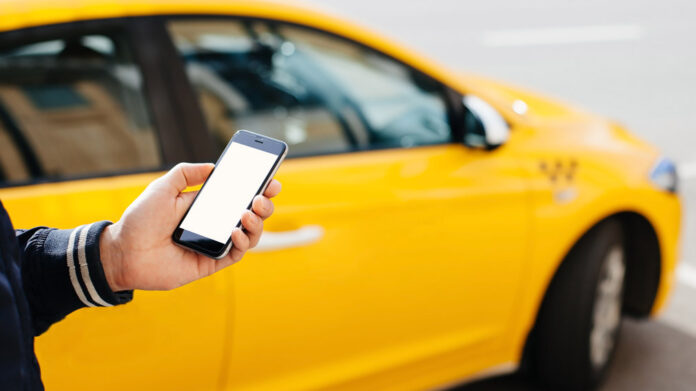 A taxi driver uses an online service app to order a ride