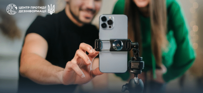 Smartphone with a social network and Russian propaganda symbols