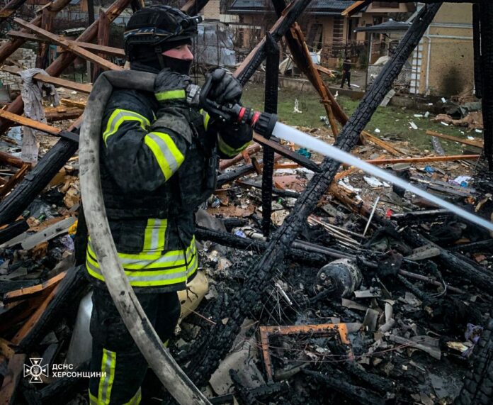 Рятувальник ДСНС гасить пожежу серед руїн будинку після російського удару