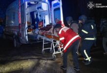 В Одесі після удару дронами поранено п’ятьох людей Рятувальники переносять постраждалу людину до карети швидкої допомоги після нічної атаки дронами в Одесі