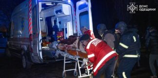 Rescuers carry an injured man to an ambulance after a nighttime drone attack in Odesa