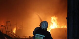 A rescuer extinguishes a large-scale fire at the Med-Service warehouse in Dnipro