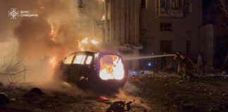 Рятувальники гасять пожежу біля палаючого автомобіля та зруйнованої багатоповерхівки