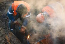 Працівники аварійної бригади ліквідовують наслідки пошкодження тепломережі в Києві взимку