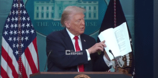 US President Donald Trump shows a document during a speech