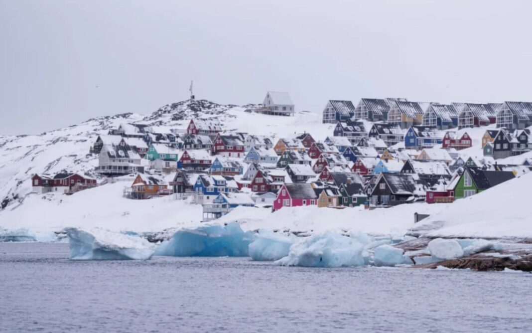 Houses in Greenland against the backdrop of the Arctic coast and glaciers