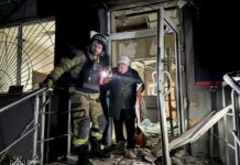 Рятувальники евакуюють жінку з пошкодженого будинку в Дніпрі