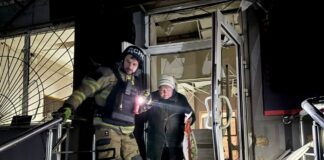 Рятувальники евакуюють жінку з пошкодженого будинку в Дніпрі