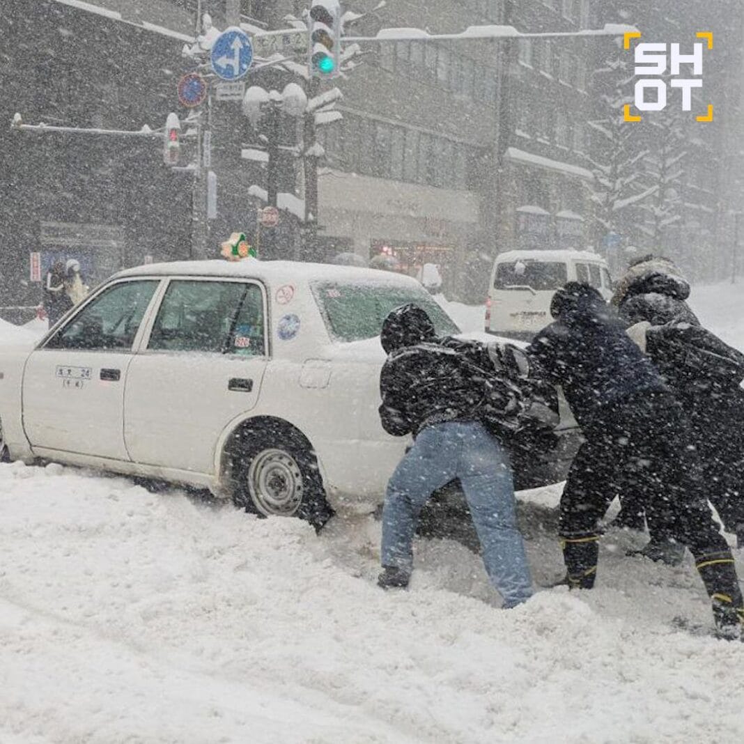 Люди штовхають авто під час сильного снігопаду в Японії