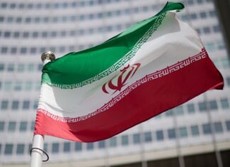 Державний прапор Ірану на тлі урядової будівлі