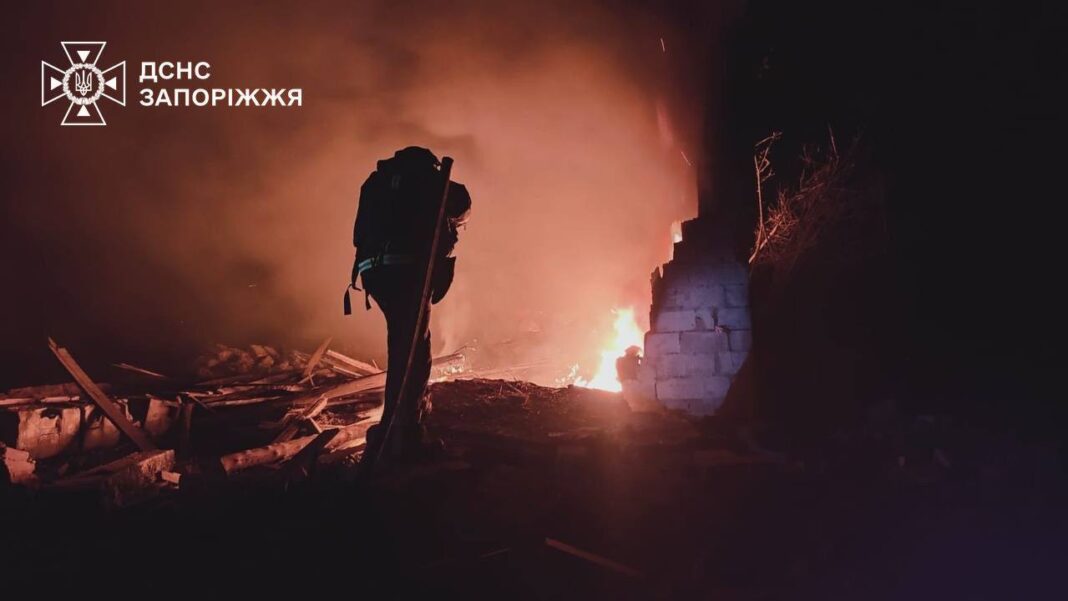 A rescuer extinguishes a fire after a drone attack in Zaporizhzhia district
