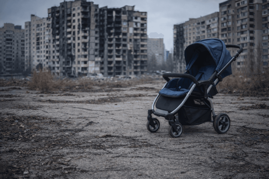 Порожня дитяча коляска на тлі міста в Україні