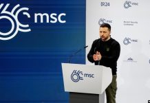 Володимир Зеленський тримає iPad під час міжнародної конференції.