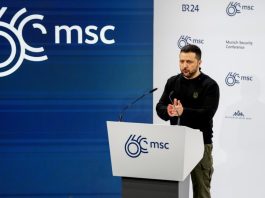 Володимир Зеленський тримає iPad під час міжнародної конференції.