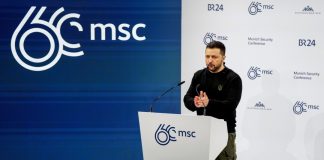 Volodymyr Zelenskyy holds an iPad during an international conference.