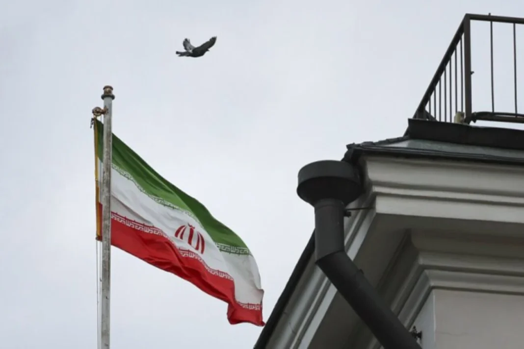 Іранський прапор на тлі Тегерана