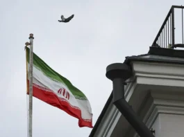 Іранський прапор на тлі Тегерана