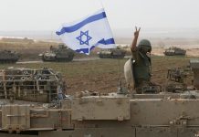 Israel to continue operation against Iran Israeli soldiers in front of military equipment during the operation