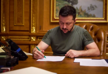 Зеленський ввів санкції проти російських та іранських ВПК Володимир Зеленський підписує документи за робочим столом.