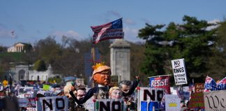 Люди тримають плакати під час протесту у США