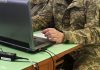 Український IT-фахівець у військовій формі працює за комп'ютером