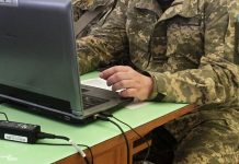 Український IT-фахівець у військовій формі працює за комп'ютером
