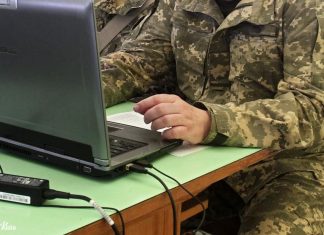 Український IT-фахівець у військовій формі працює за комп'ютером