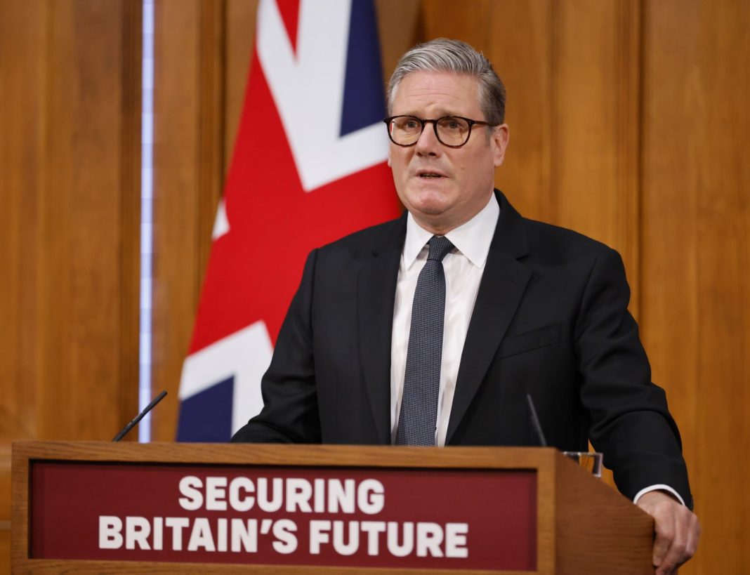 Screenshot_1 Keir Starmer speaks to supporters against the backdrop of the British flag.