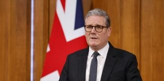 Кір Стармер виступає перед прихильниками на тлі британського прапора.