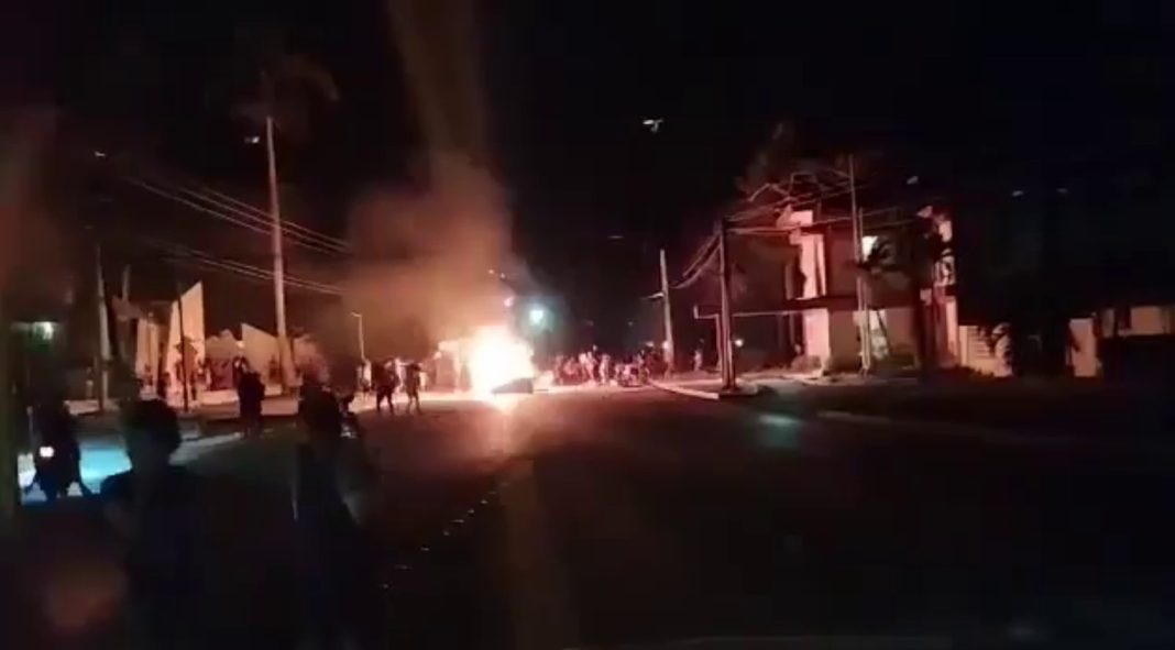 People are protesting on the streets of Cuba, a building is on fire.