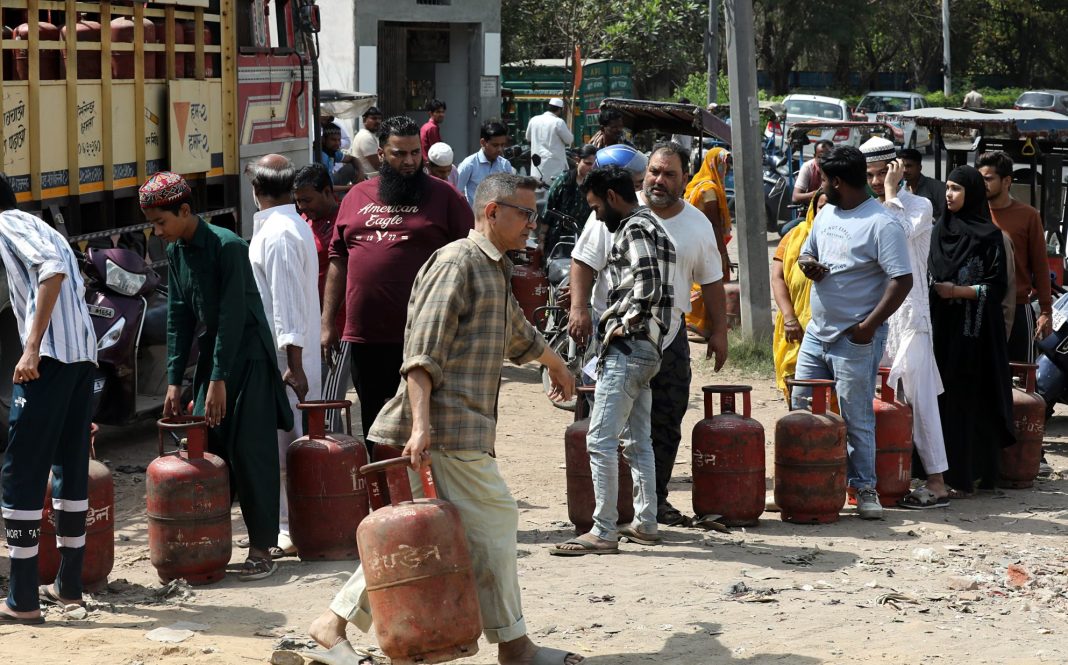 Індійці чекають у черзі за скрапленим газом на вулиці міста.
