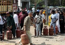 Індійці чекають у черзі за скрапленим газом на вулиці міста.