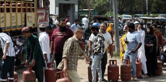 Indians wait in line to buy liquefied petroleum gas on the streets of the city.