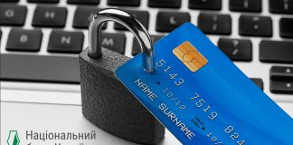 The photo shows a bank card and a computer screen with financial data.