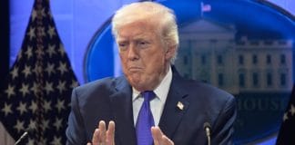 Дональд Трамп на брифінгу у Білому домі, прапори США на тлі