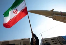 Iran threatens to strike at the US and Israel Iranian flag on the background of military equipment