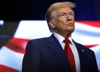 ТРАМП ВТРАЧАЄ ІНТЕРЕС ДО МИРНИХ ПЕРЕГОВОРІВ ЩОДО УКРАЇНИ Трамп на фоні прапора