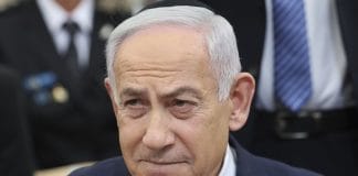 Netanyahu in front of the Israeli flag during a speech