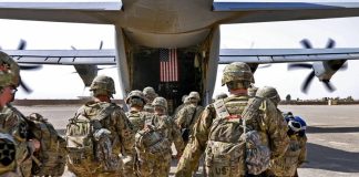 Американські військові готуються до посадки на військовий транспортний літак.