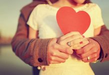 Пара тримає руки на фоні заходу сонця