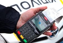 A policeman writes a fine to a driver on a Ukrainian road.